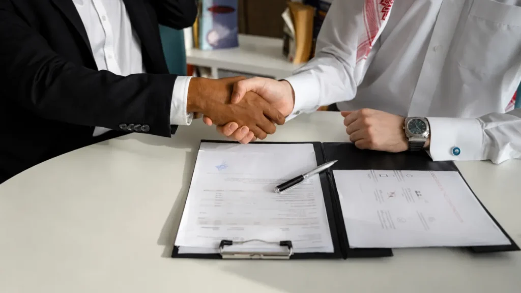 Business executives shaking hands over signed contract for Local SEO Services.